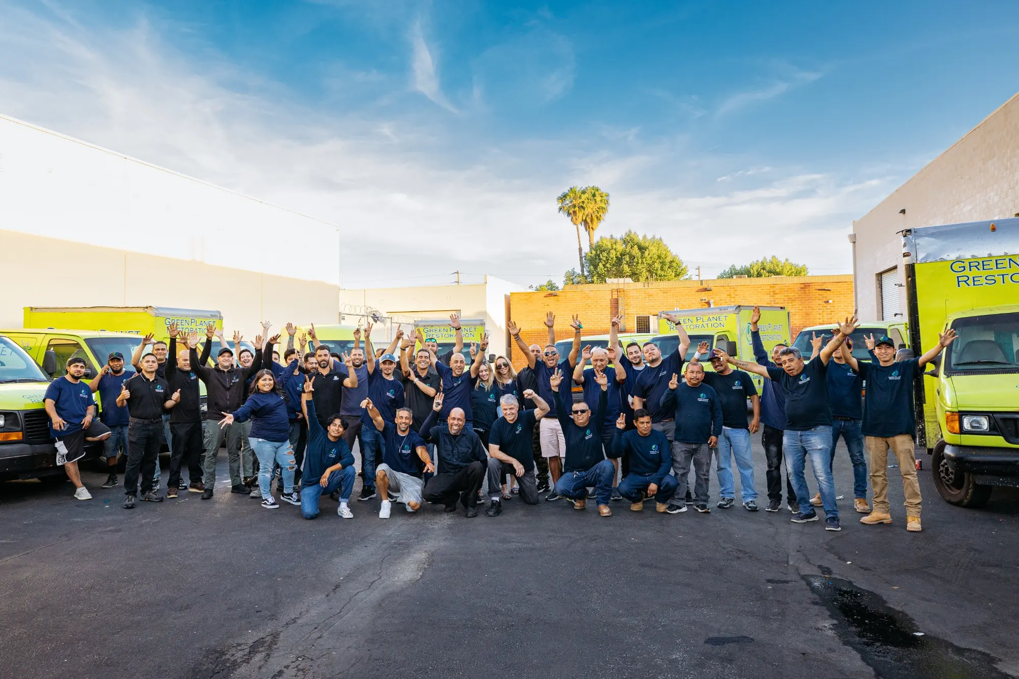Green Planet Restoration team standing with their trucks
