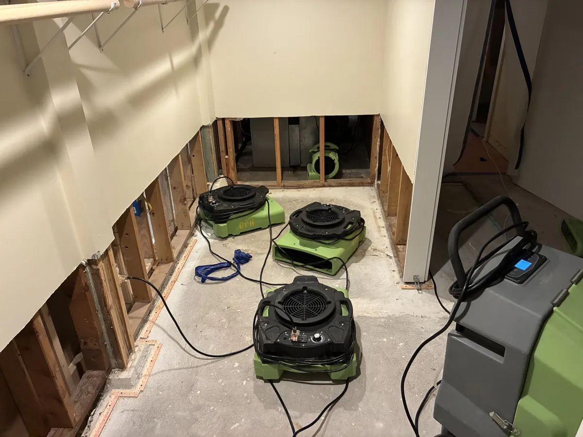 Dehumidifier, air scrubber and air movers drying a water-damaged room