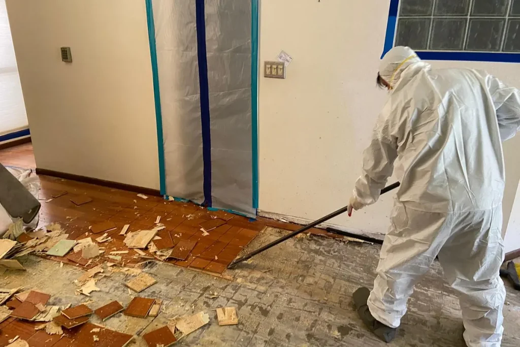 Technician in protective suit cleaning up debris
