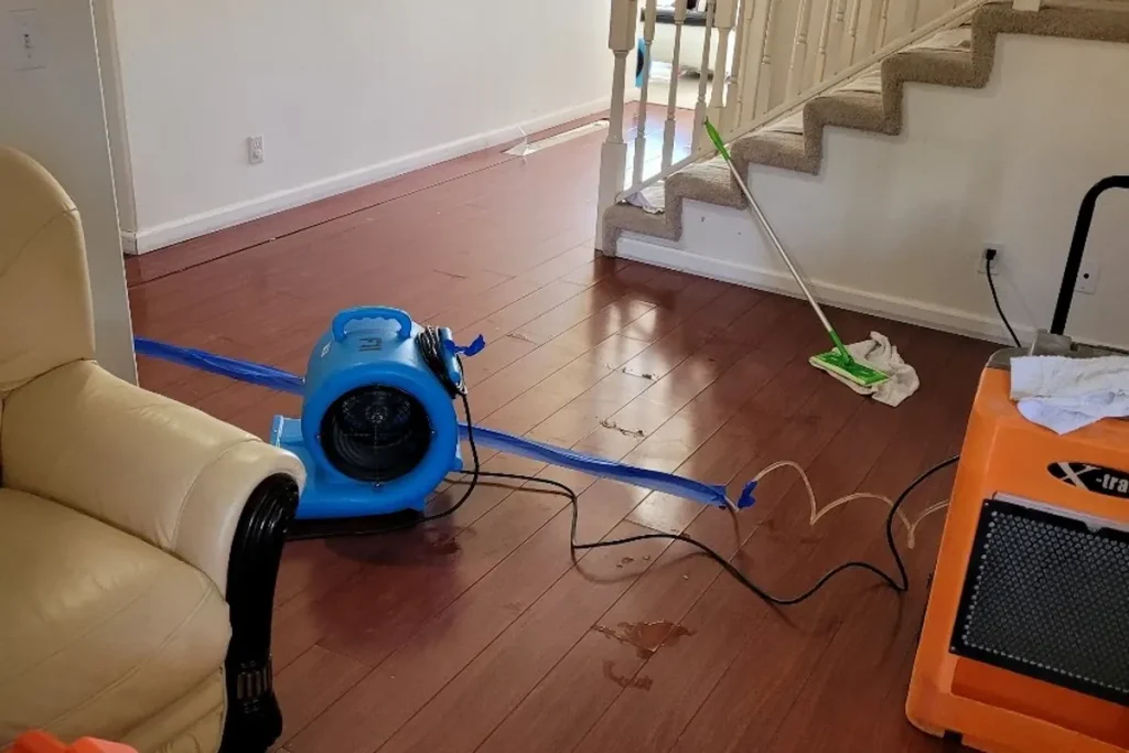 Air movers and a dehumidifier drying a living room floor