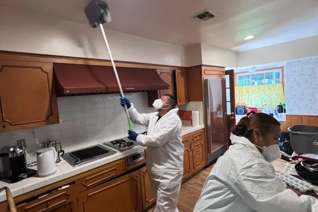 Technicians cleaning soot from kitchen ceilings